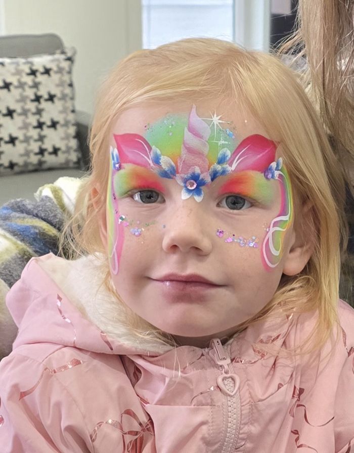 Child with colourful unicorn face painting